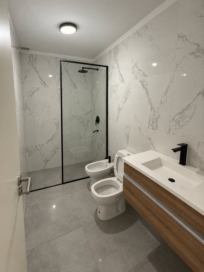 Baño con porcelanato símil mármol y mueble de madera