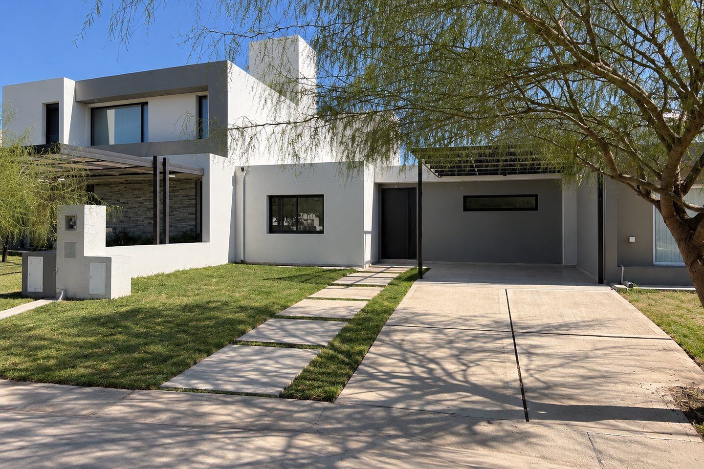 Frente completo de la vivienda sobre el lote, con el jardín delantero