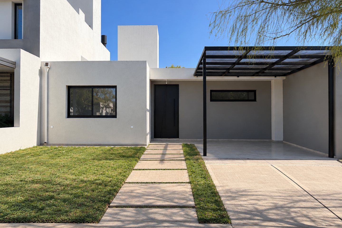 Frente de la vivienda Mza 34 Lote 20, con la pérgola-cochera y el camino de acceso