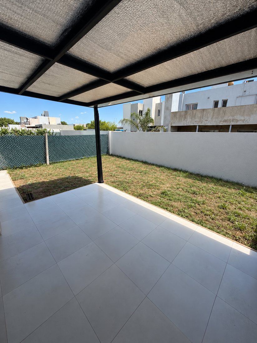 Galería con media sombra y patio con césped