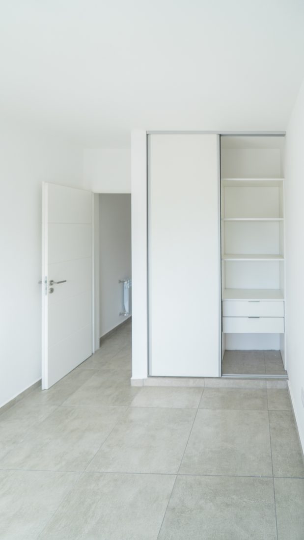 Dormitorio con placard de puertas corredizas y cajonera