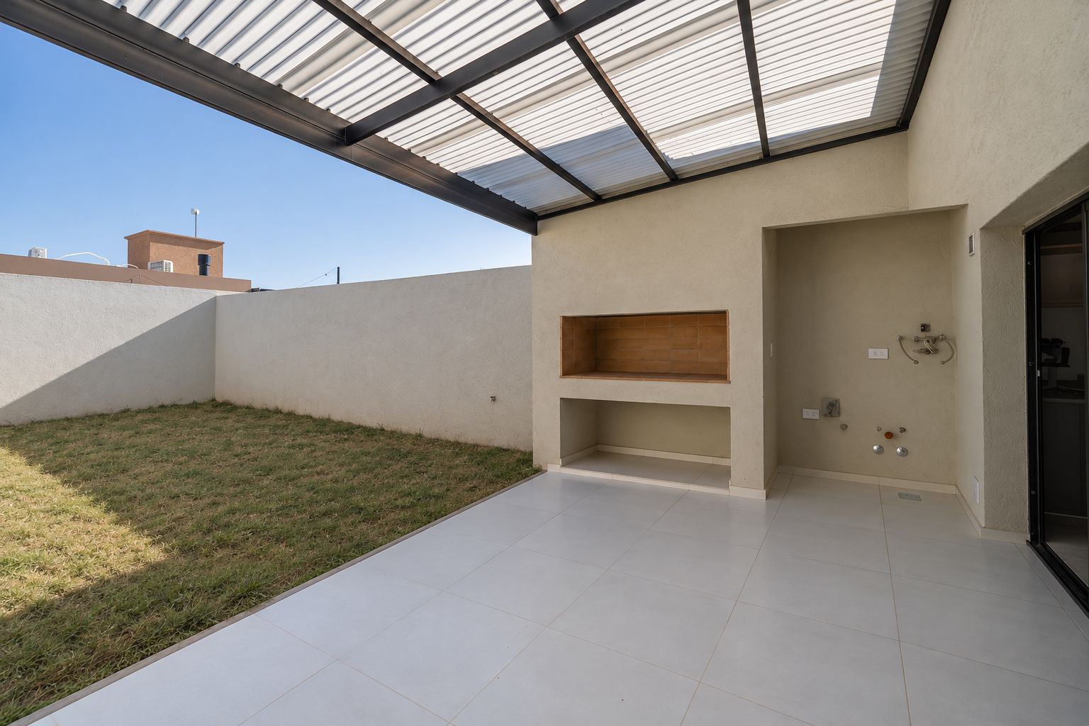 Galería con asador, piso porcelanato y conexiones de lavadero