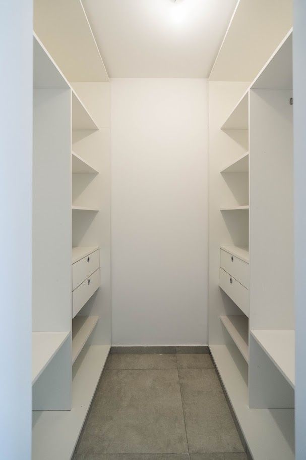 Vestidor con estantería a ambos lados y cajoneras